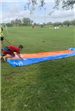 Teen boy mid leap onto a slip n slide.
