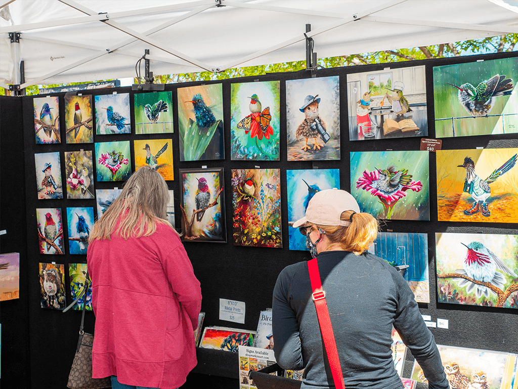 Two customers look at paintings