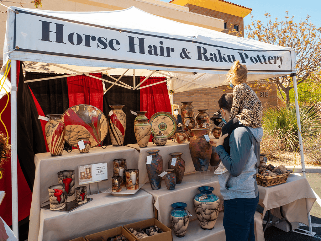 Man with girl on his shoulders at booth