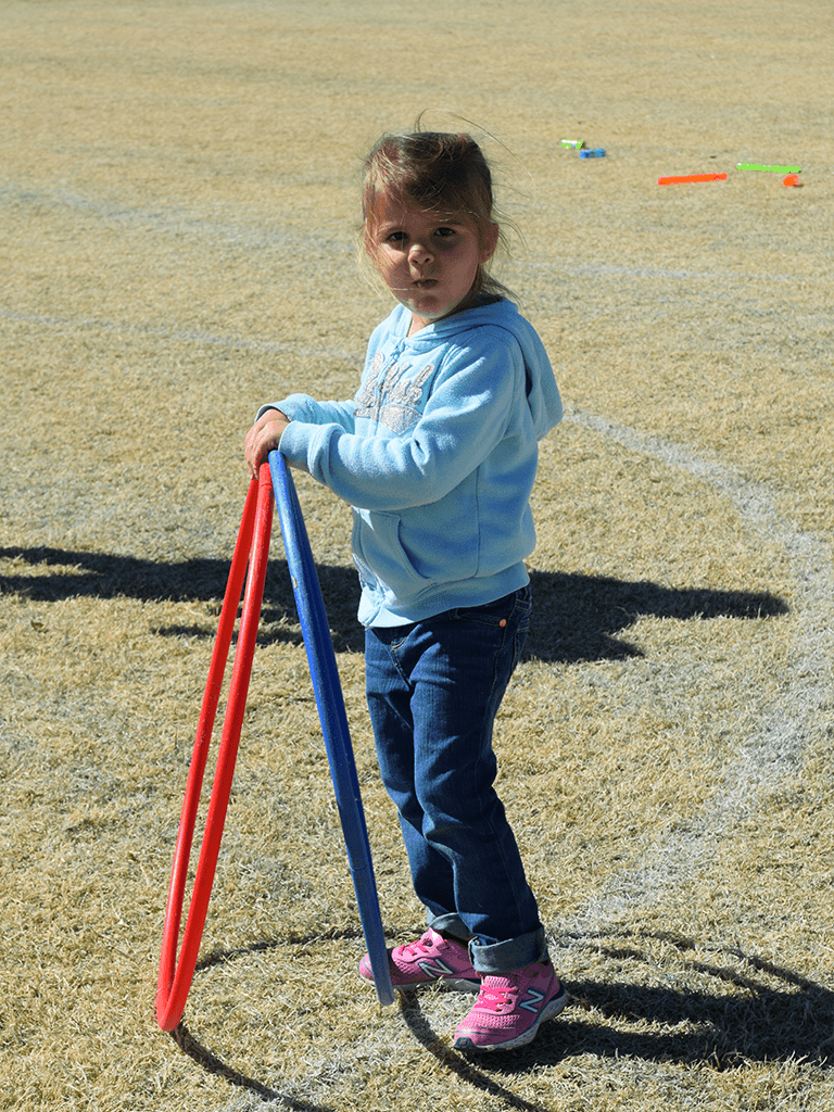 Little girl with hula hoops and bubbles in background